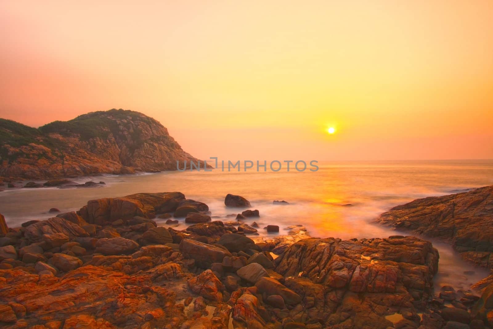 Sea rocks at sunset in Hong Kong under long exposure by kawing921