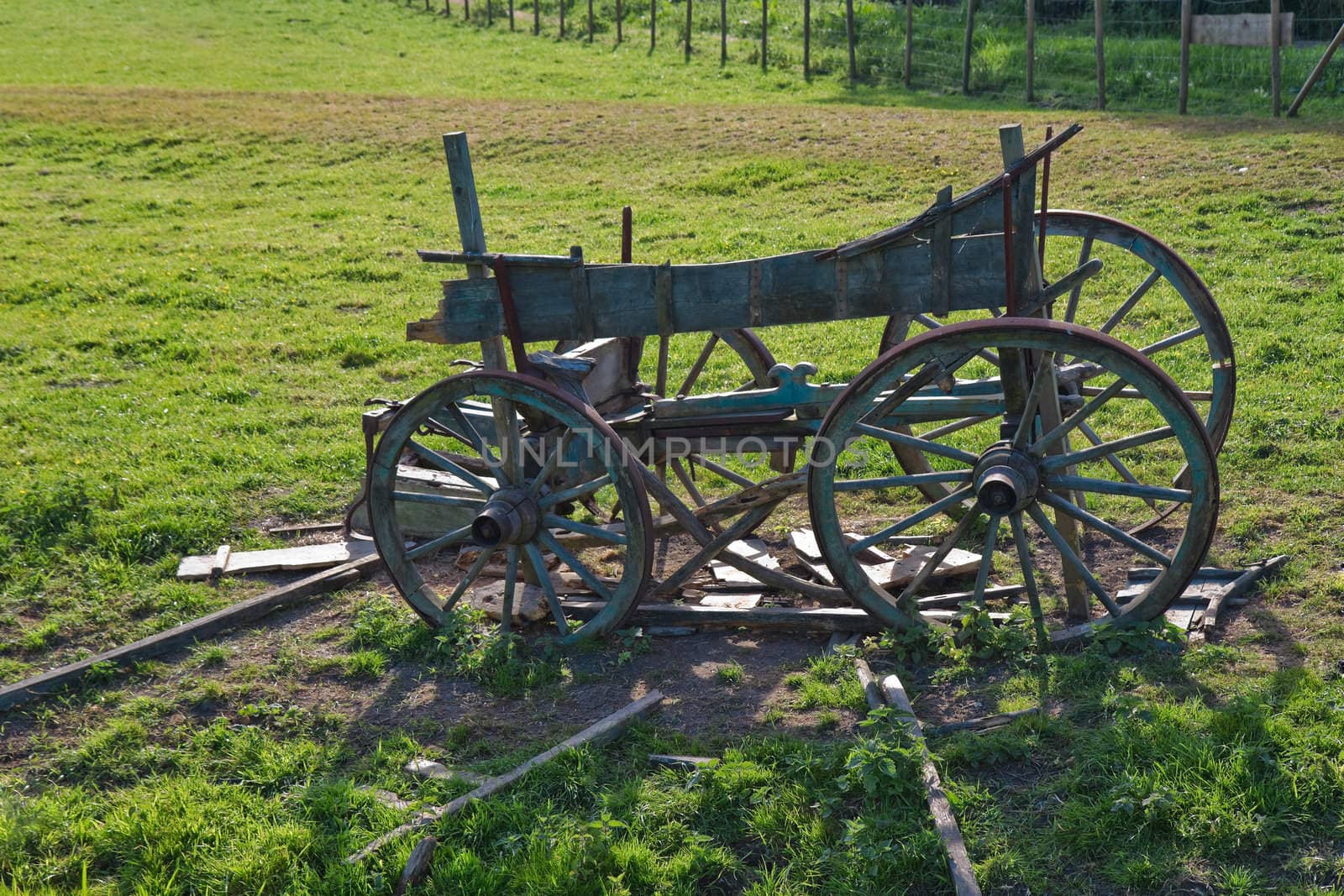 Old wooden horse cart on a field by Colette