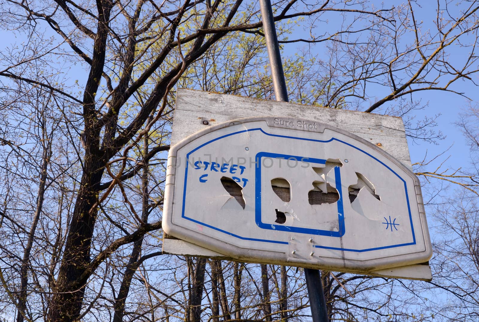 Broken street basketball board in an abandoned park.