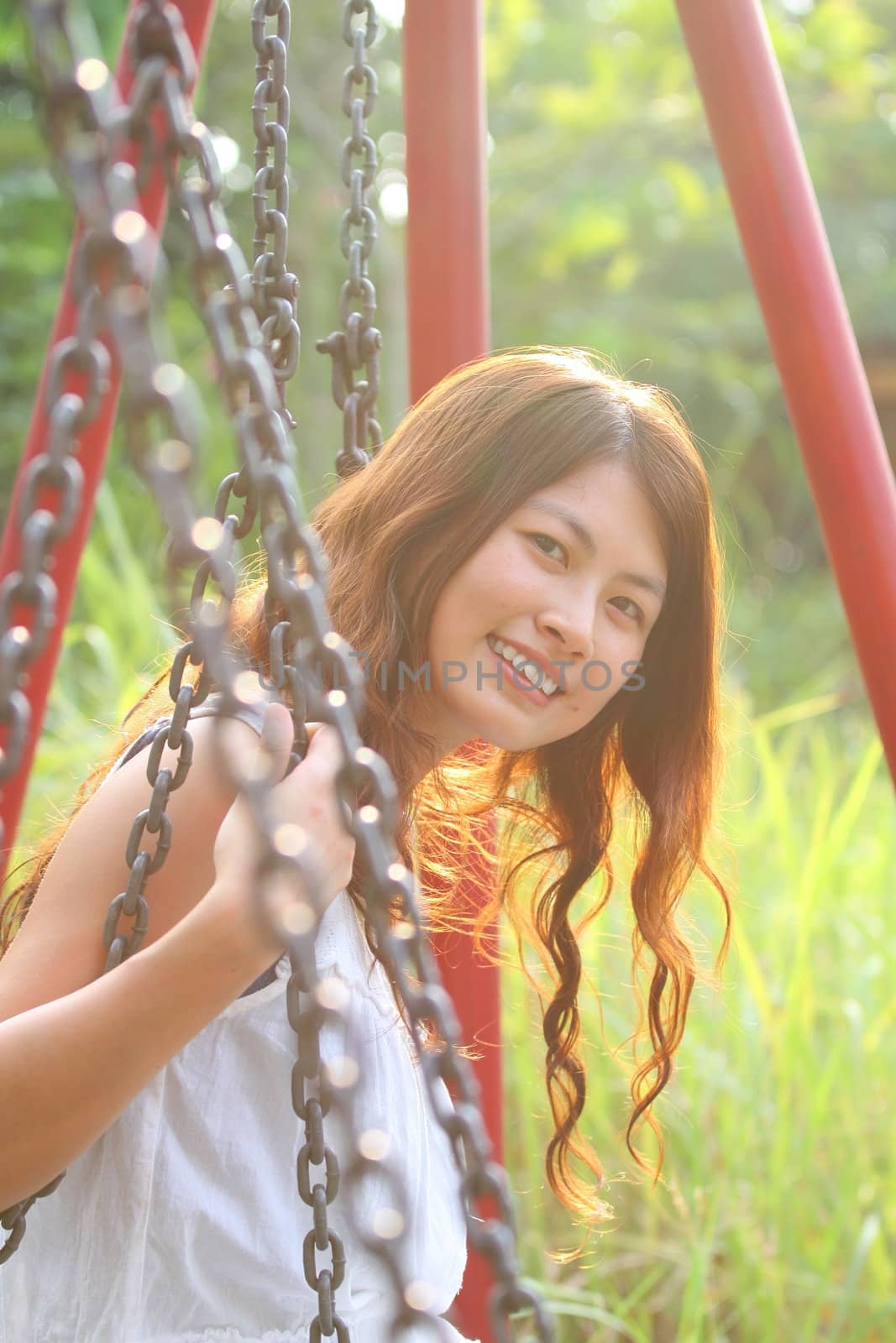 A beautiful and cheerful asian girl playing swing by kawing921