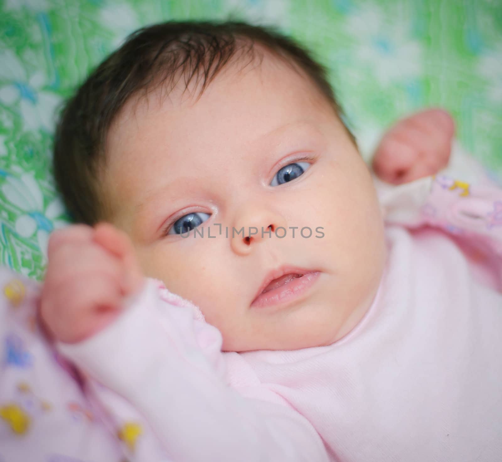 Beautiful cute baby girl is lying in a bed.