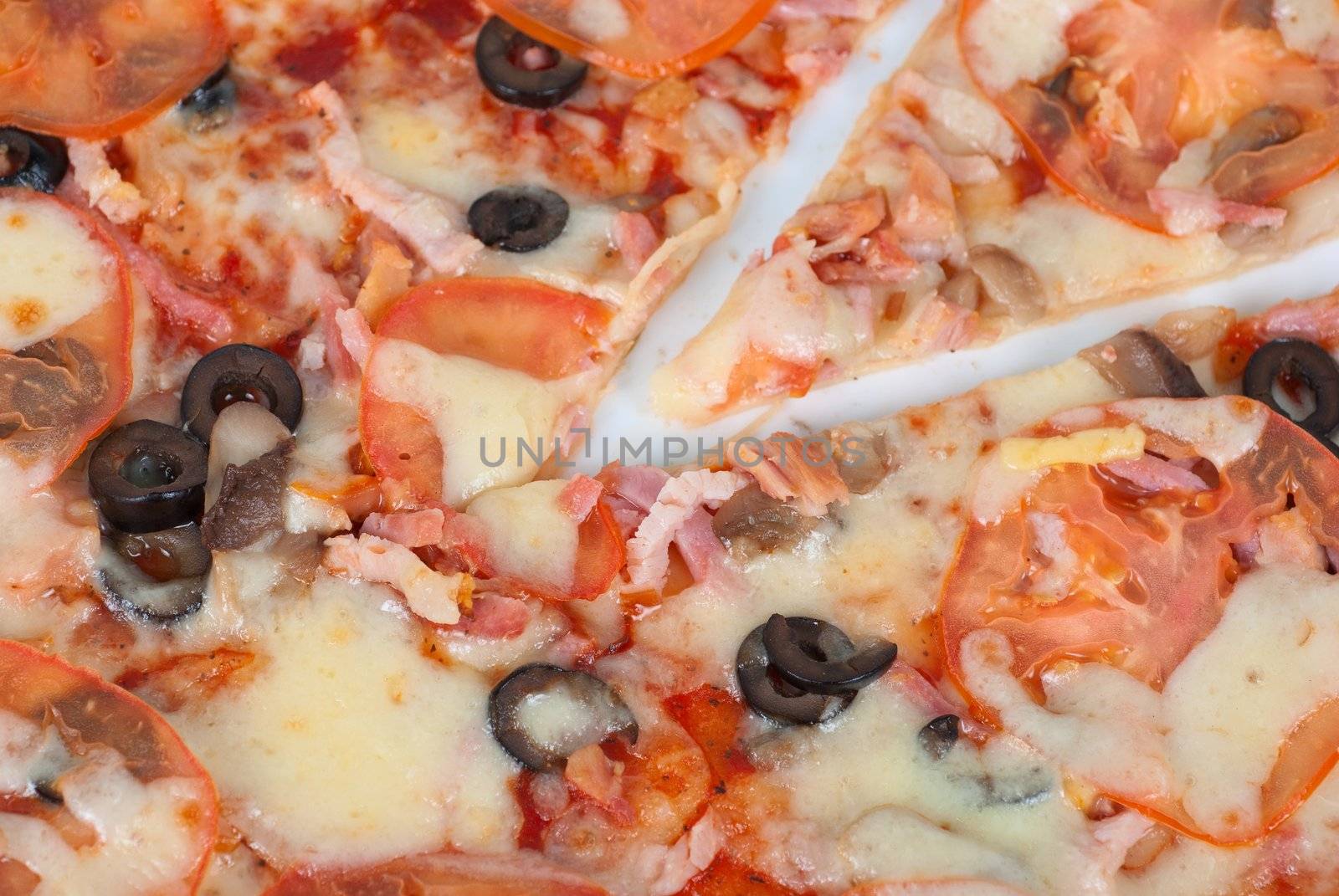 meat pizza closeup with carbonado ham, tomato, olive and mozzarella cheese