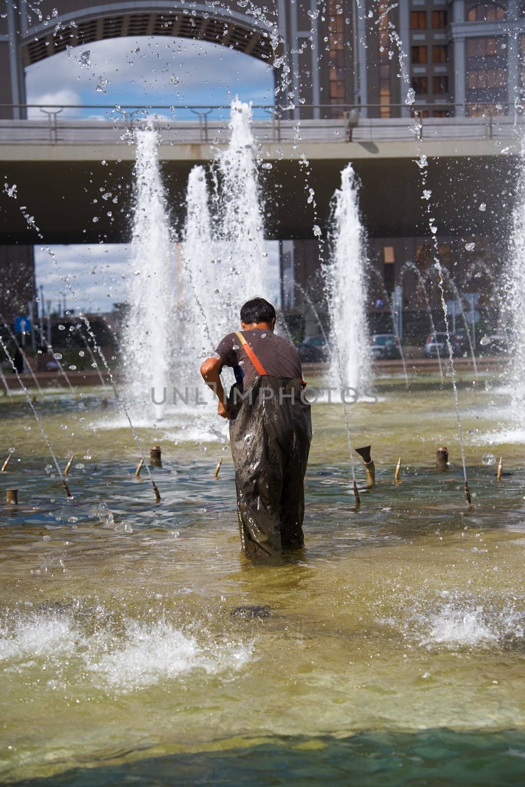 Men clean of fountain pool. Astana, Kazakhstan.