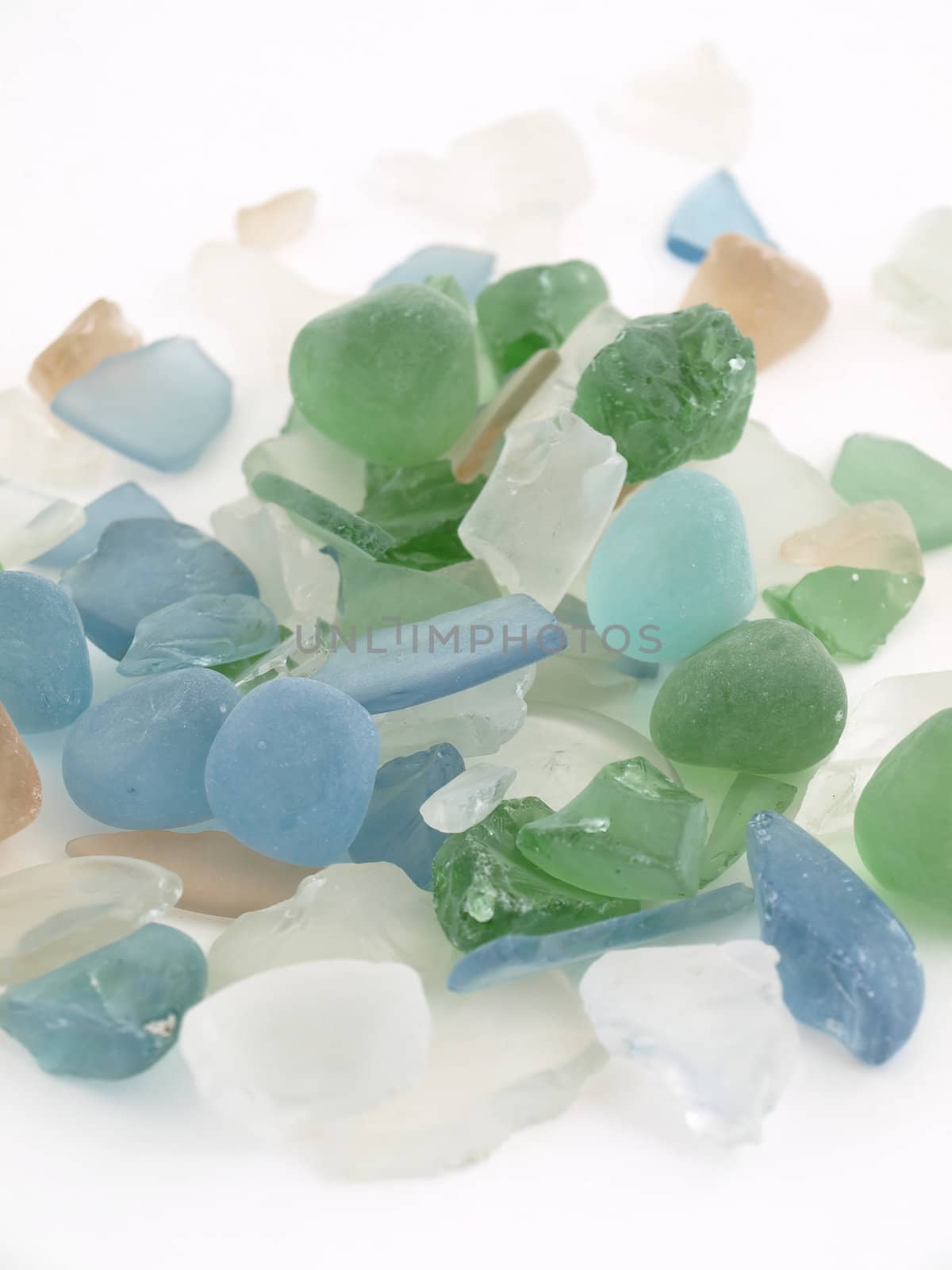 Colorful stones of glass in various blue tones isolated over a white background.