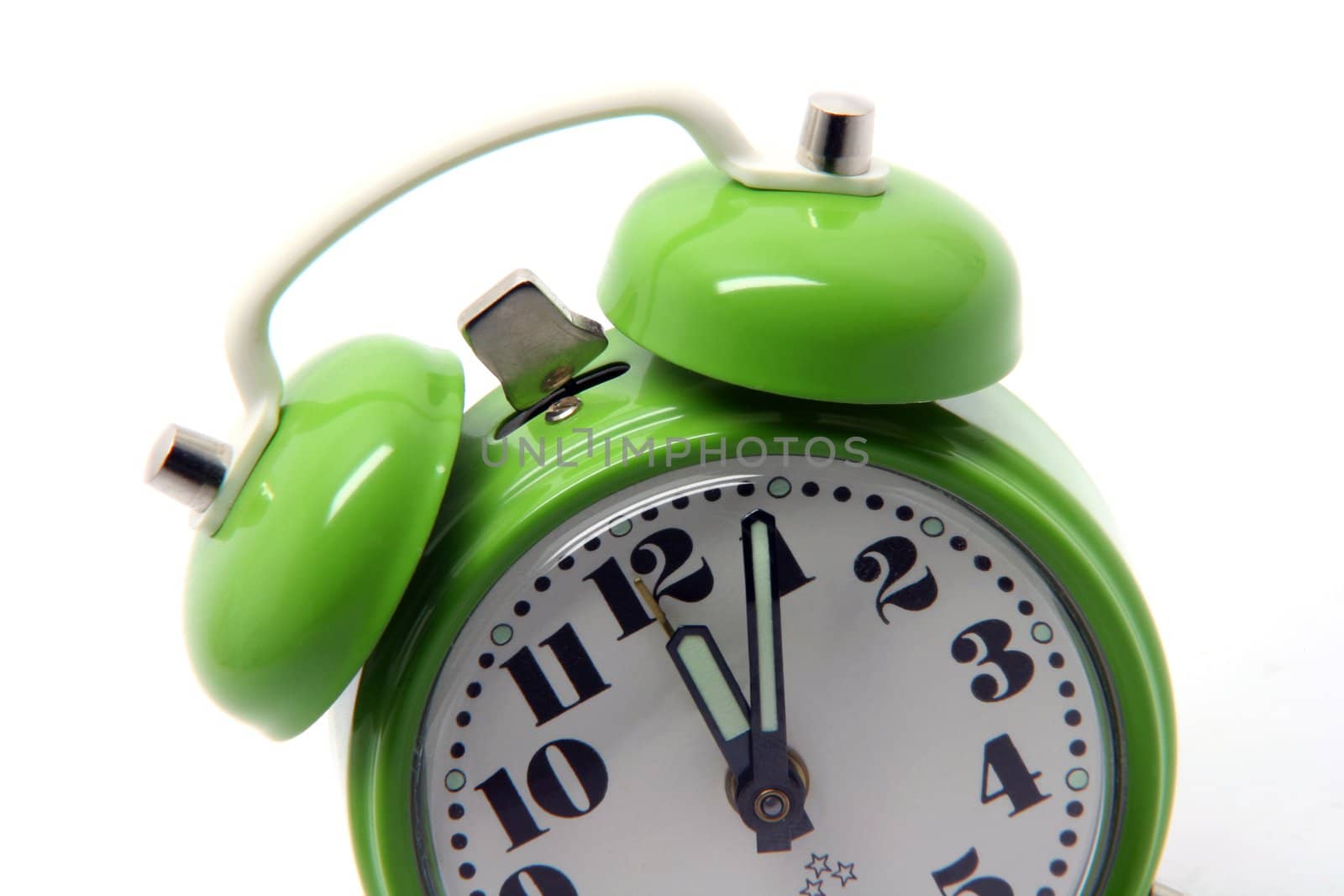 small green alarm clock at twelve oclock isolated on white background