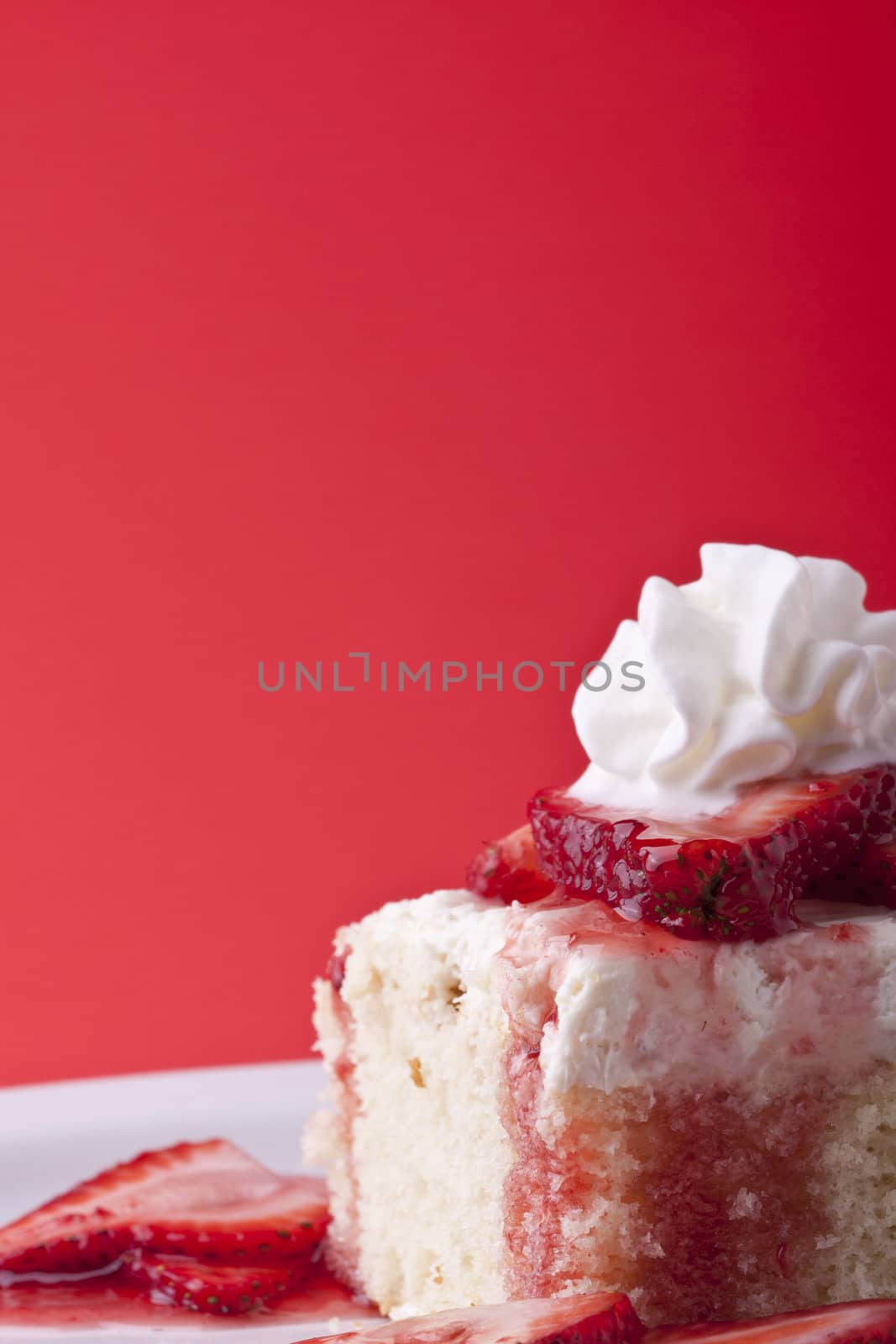 strawberry shortcake on a red background sliced berries and whipped cream