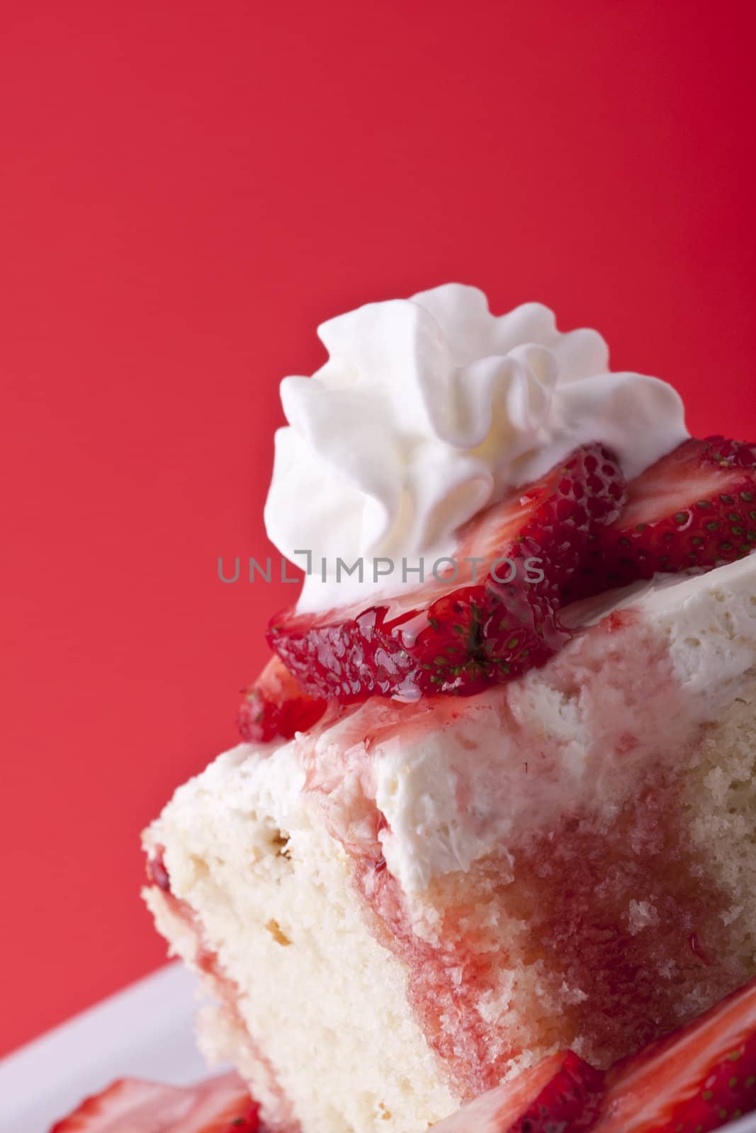 strawberry shortcake on a red background sliced berries and whipped cream