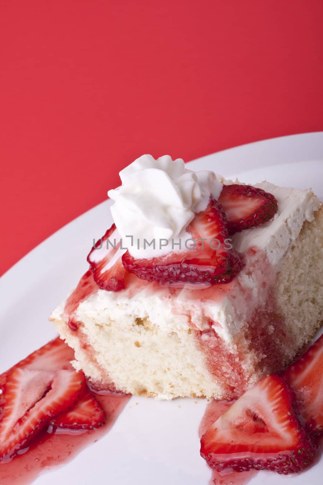 strawberry shortcake on a red background sliced berries and whipped cream