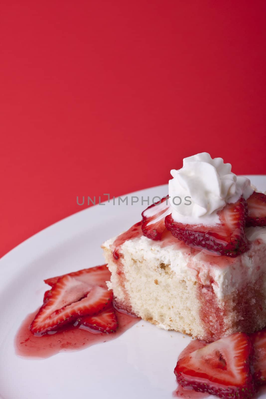 strawberry shortcake on a red background sliced berries and whipped cream