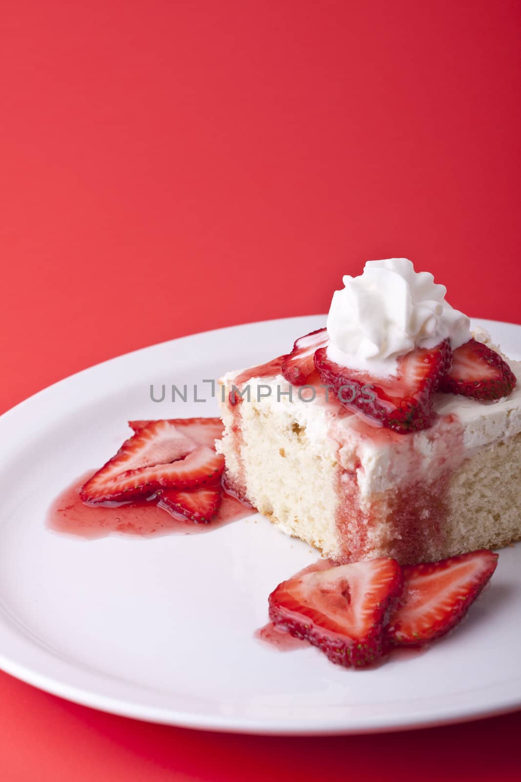 strawberry shortcake on a red background sliced berries and whipped cream