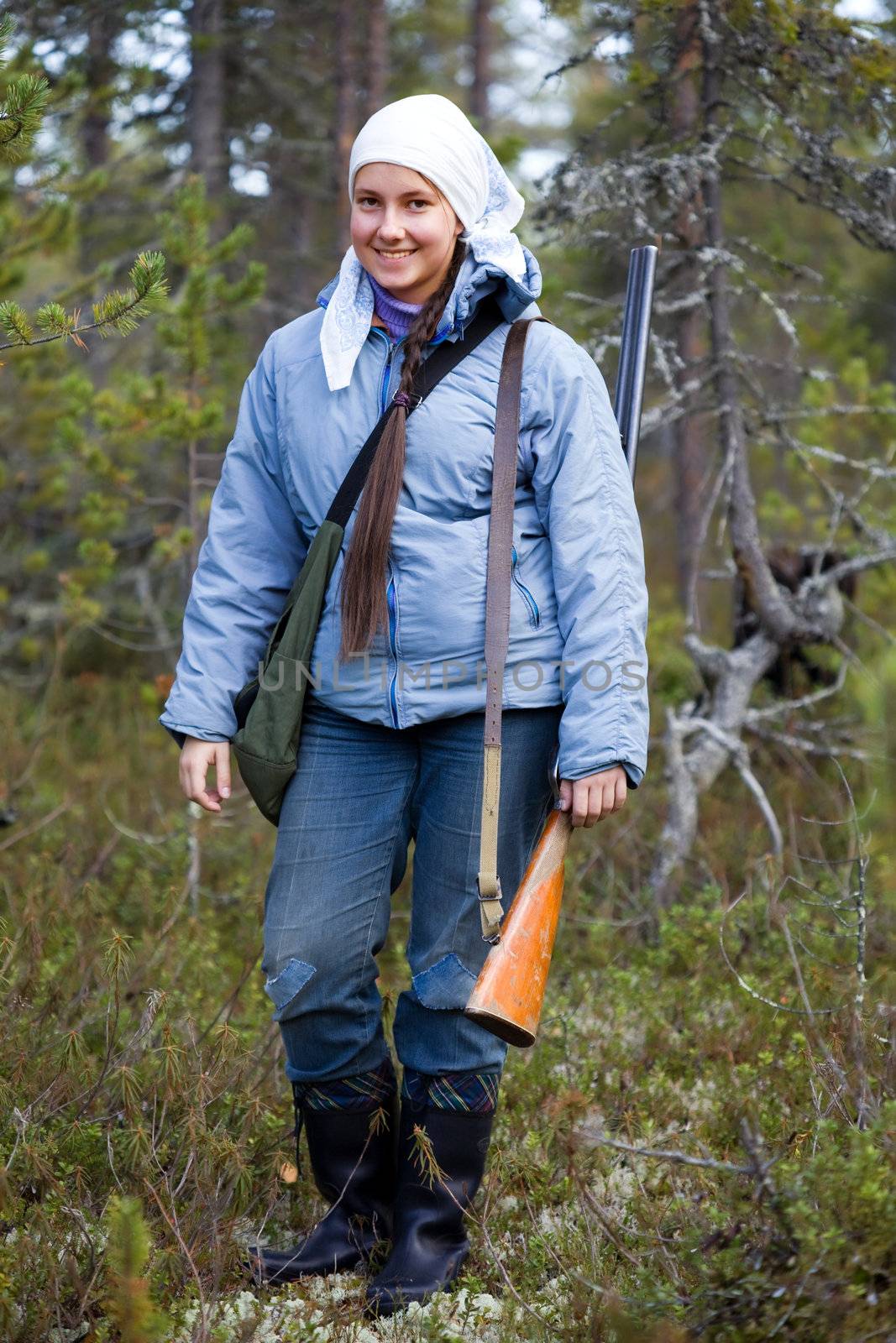 Girl with a shotgun in the autumn forest