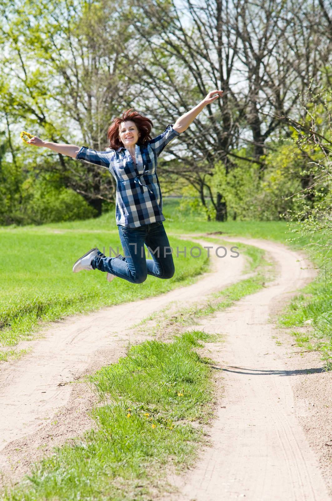The happy woman has jumped up over road