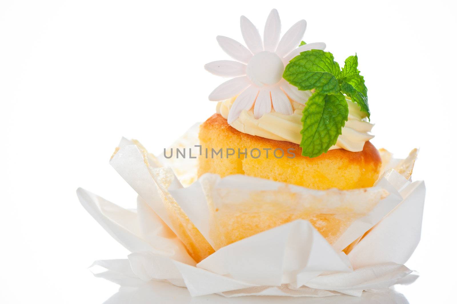 Cupcake with vanilla cream mint leaf and sugar flower on a white background