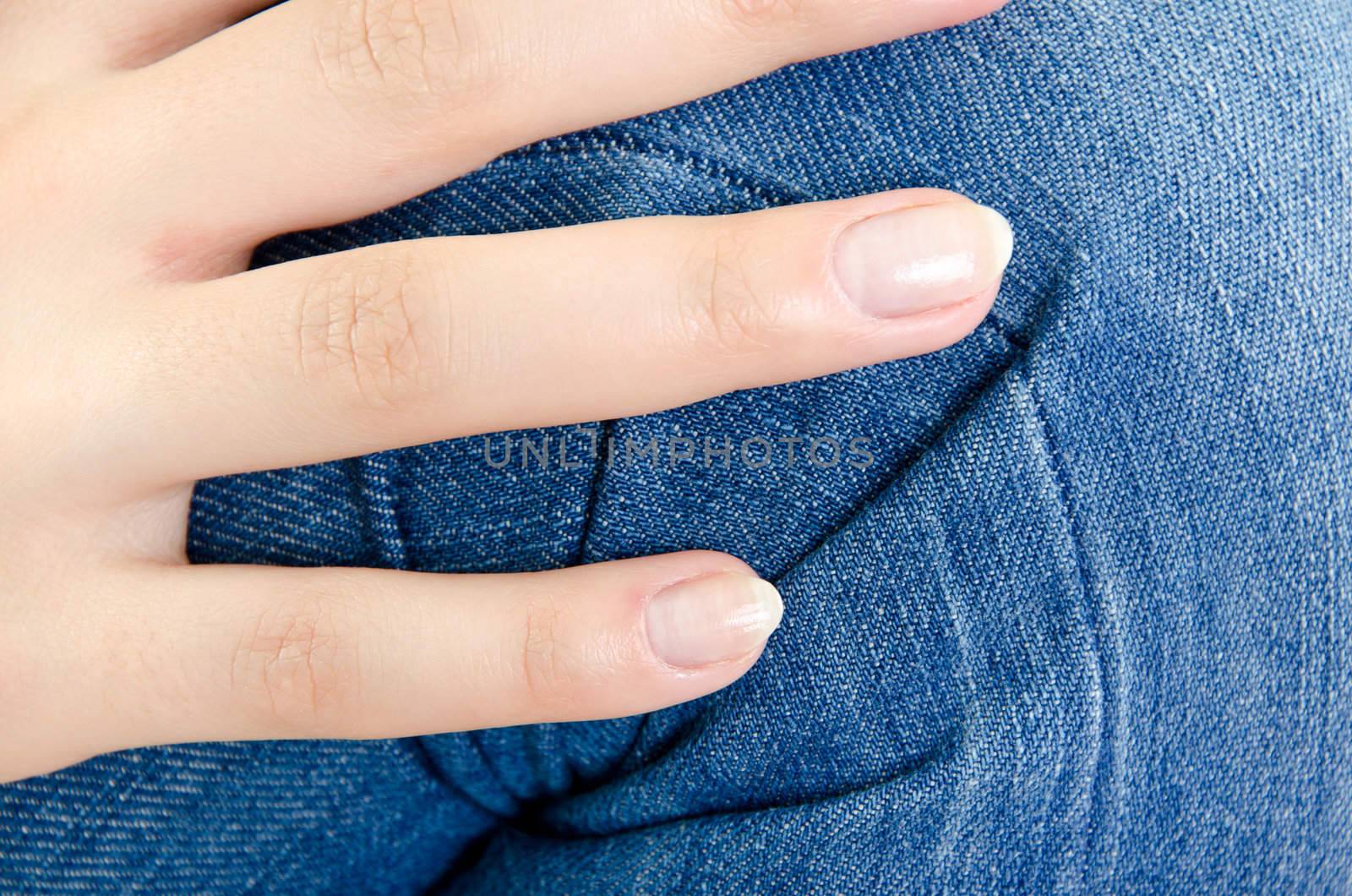 Women's knee in jeans with folds closeup