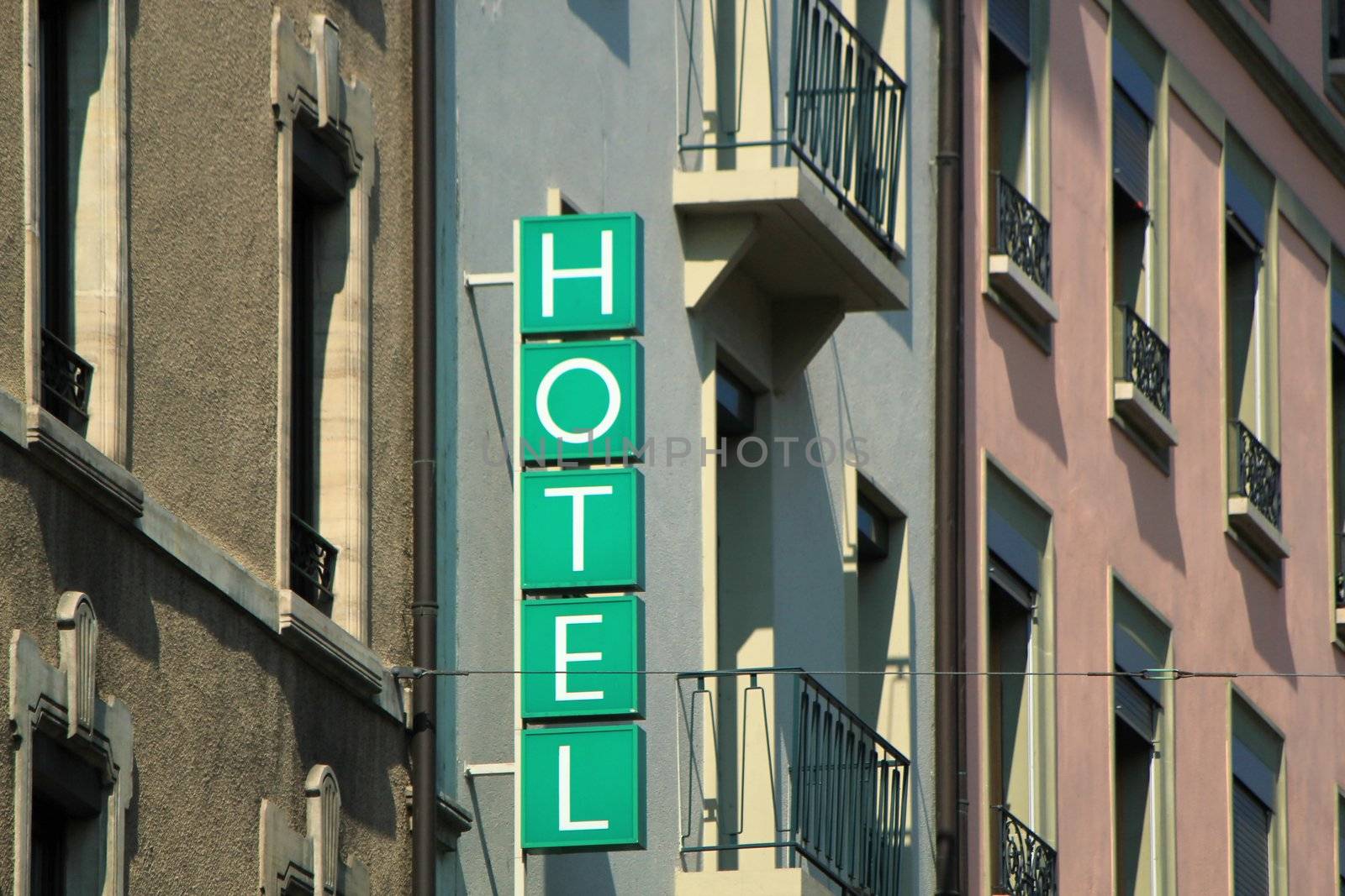 Hotel green sign on the side of old buildings in the city