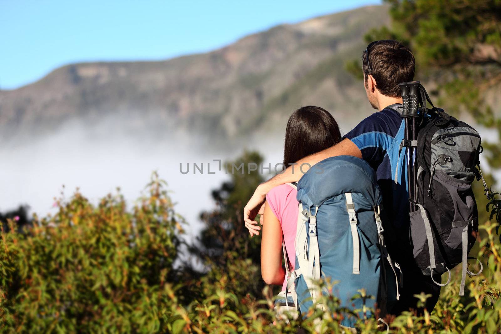 Couple hiking looking at view during hike in forest on Tenerife, Canary Islands, Spain