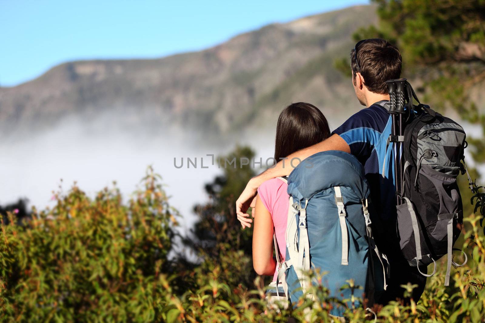 Couple hiking looking at view by Maridav