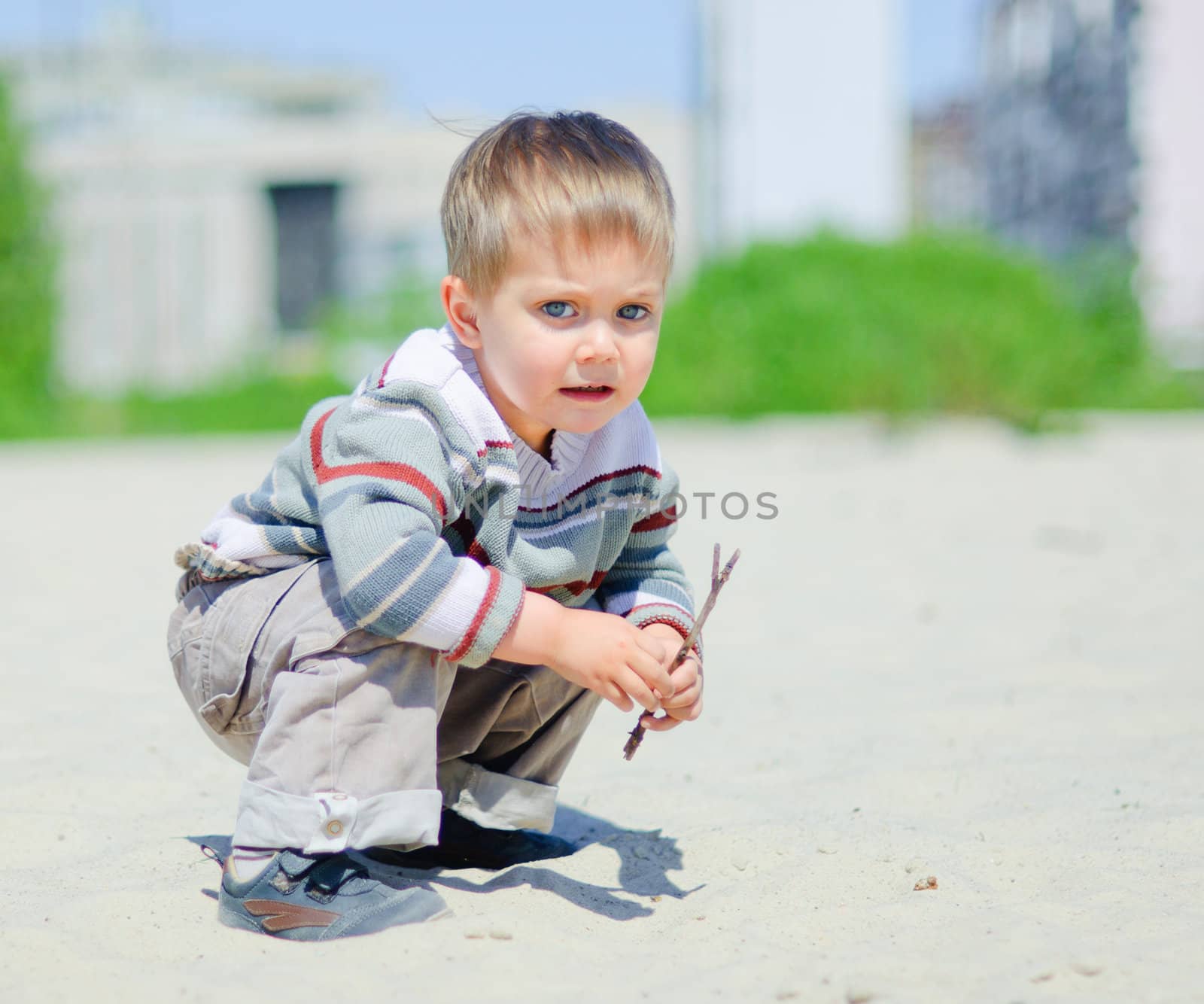 The cute boy plaing on a sand