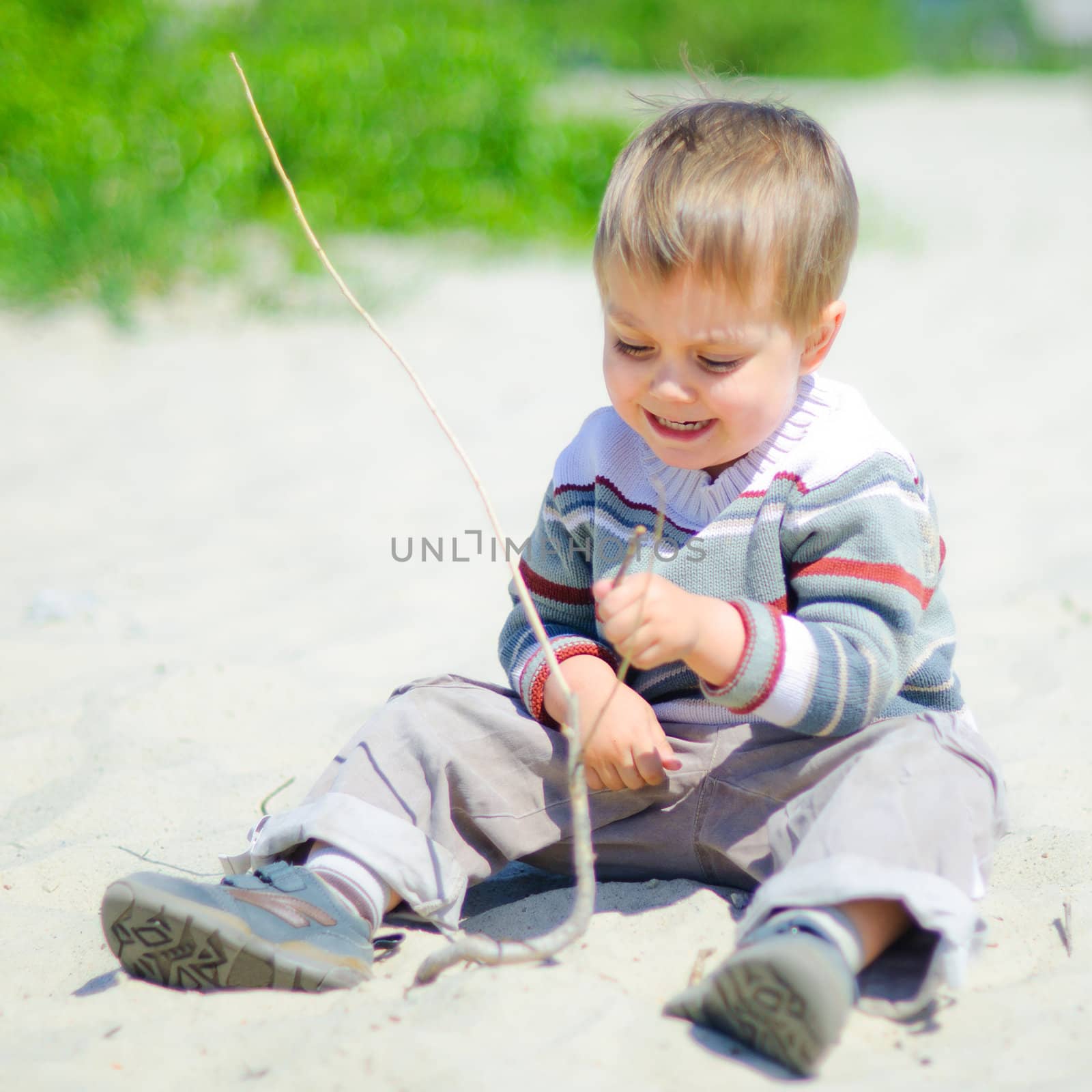 The cute boy plaing on a sand