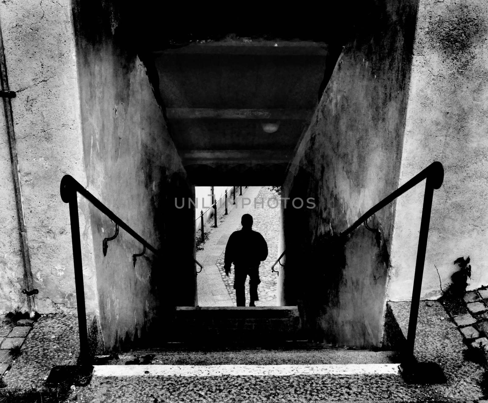 Man walking down the stairs. Dark feeling.