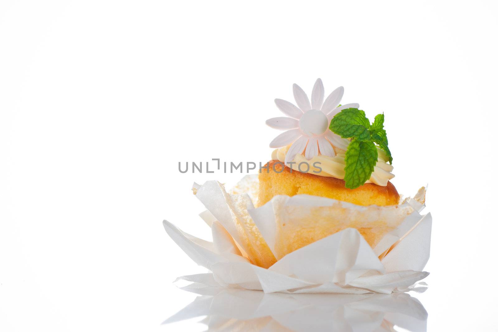 Cupcake with vanilla cream mint leaf and sugar flower on a white background