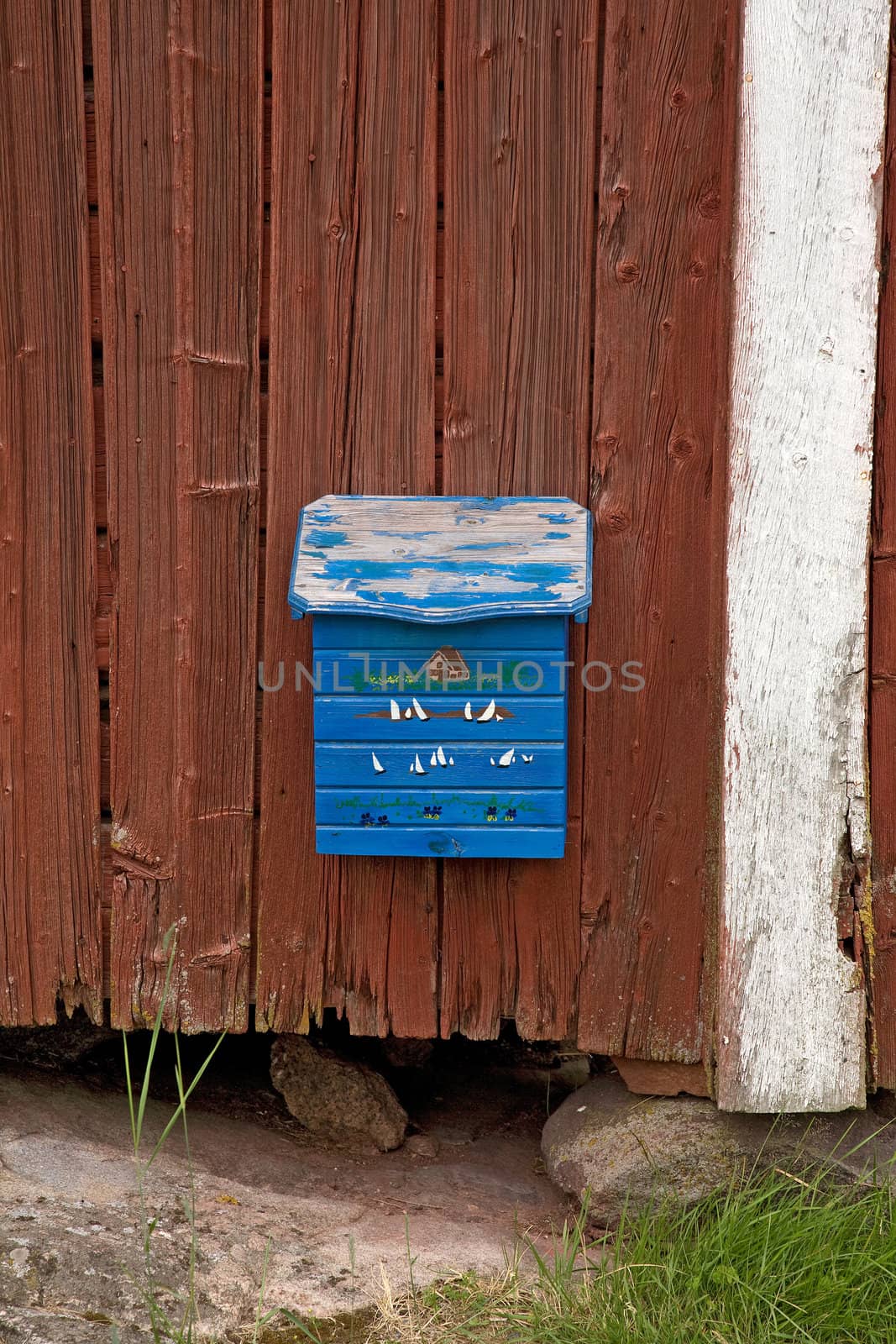 The blue vintage wooden mail box at wooden wall 