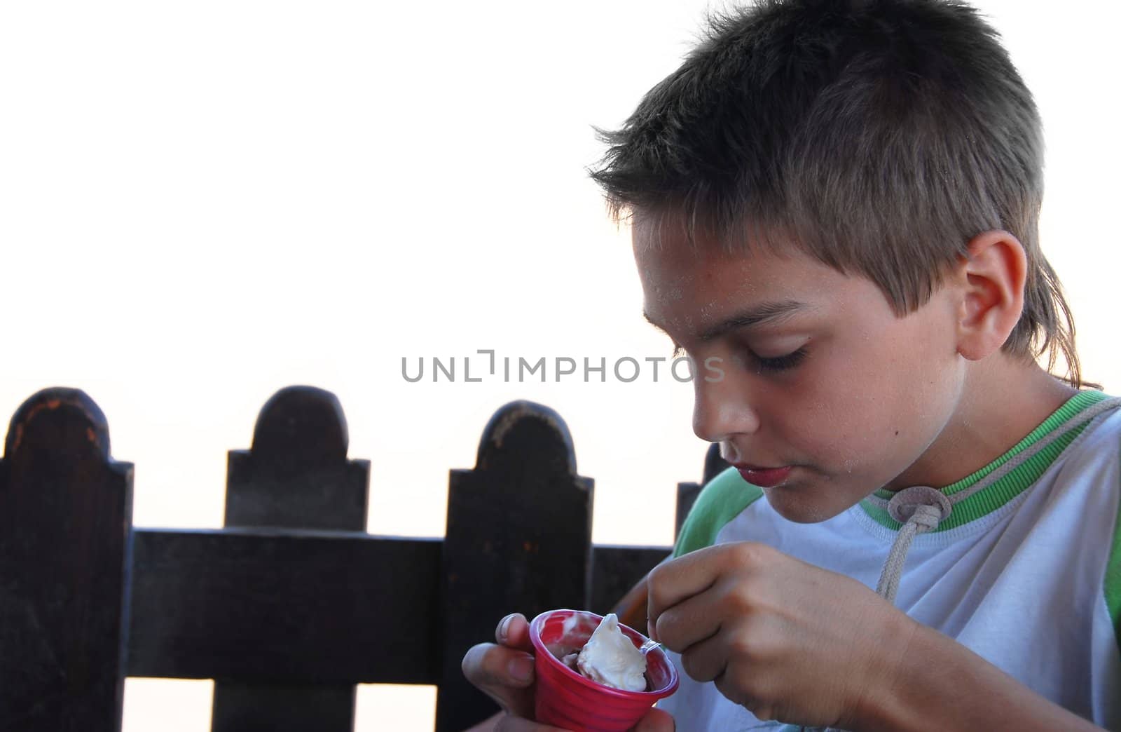 teenage caucasian boy with sea salt on face eating ice-cream in beach cafe