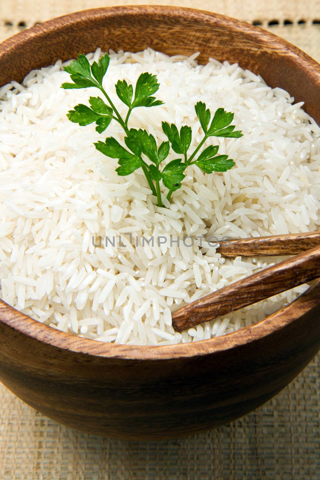 uncooked rice grains in wood bowl 