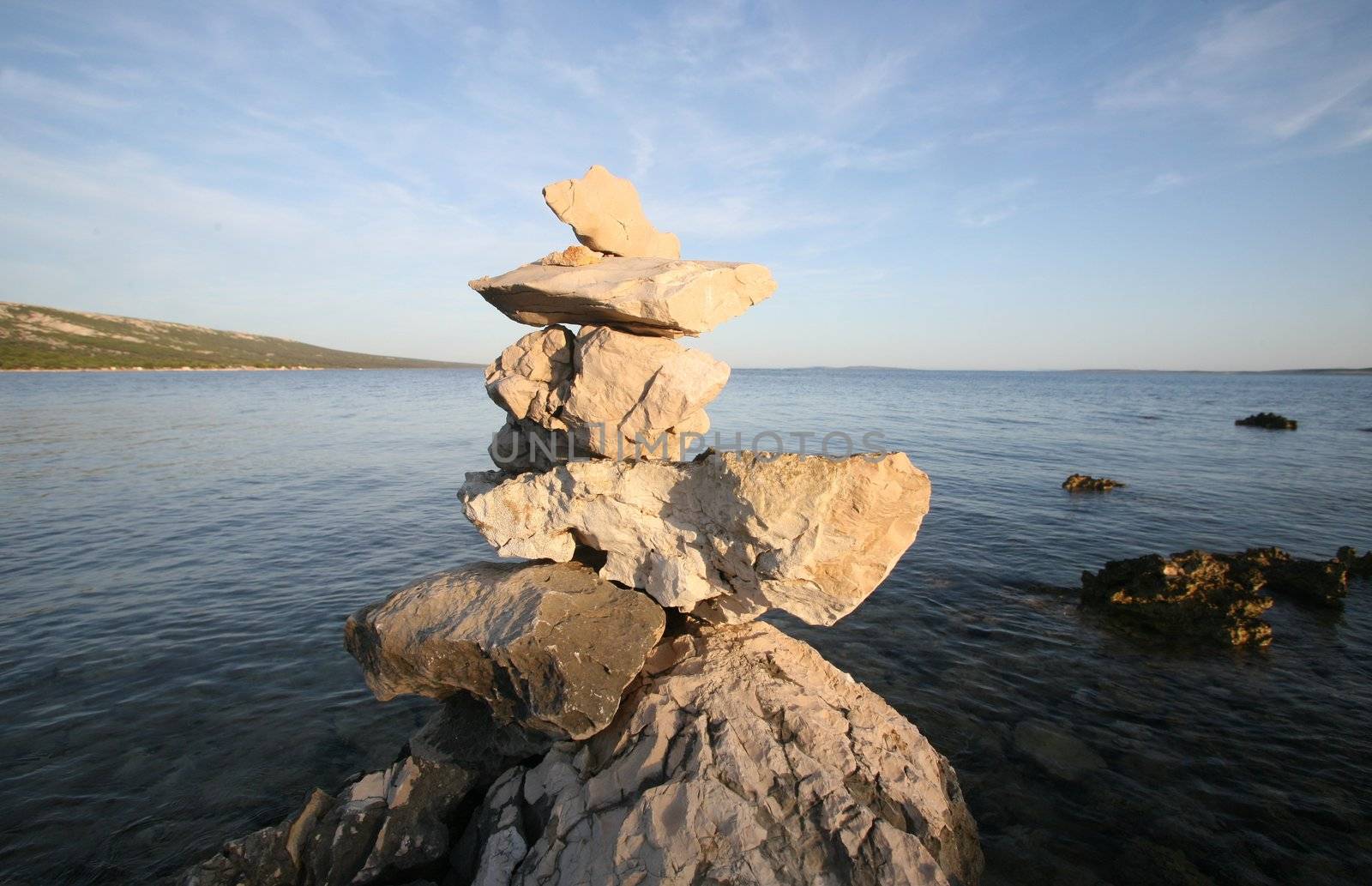 Cross, rocks stacked one one top of another on beach