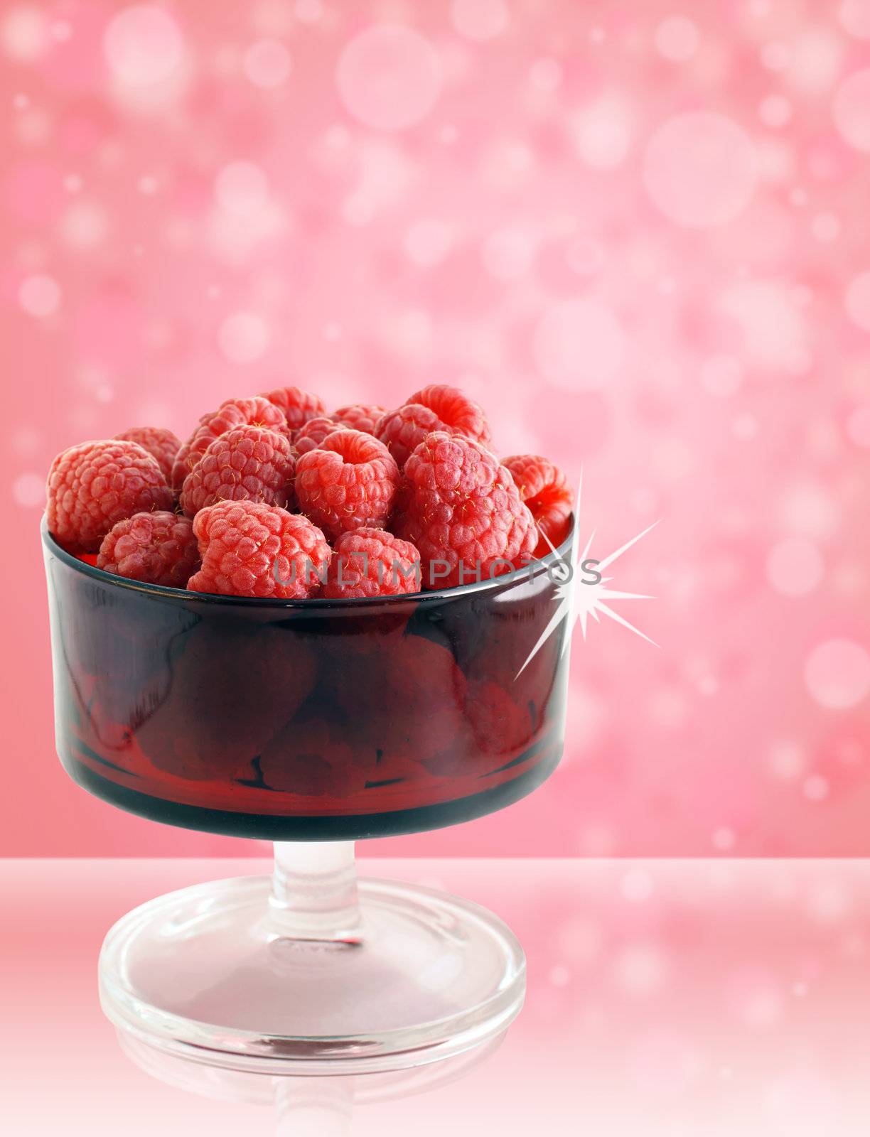 So good they sparkle: sweet,delicious and healthy raspberries in a vintage red colored glass bowl on fun pink background
