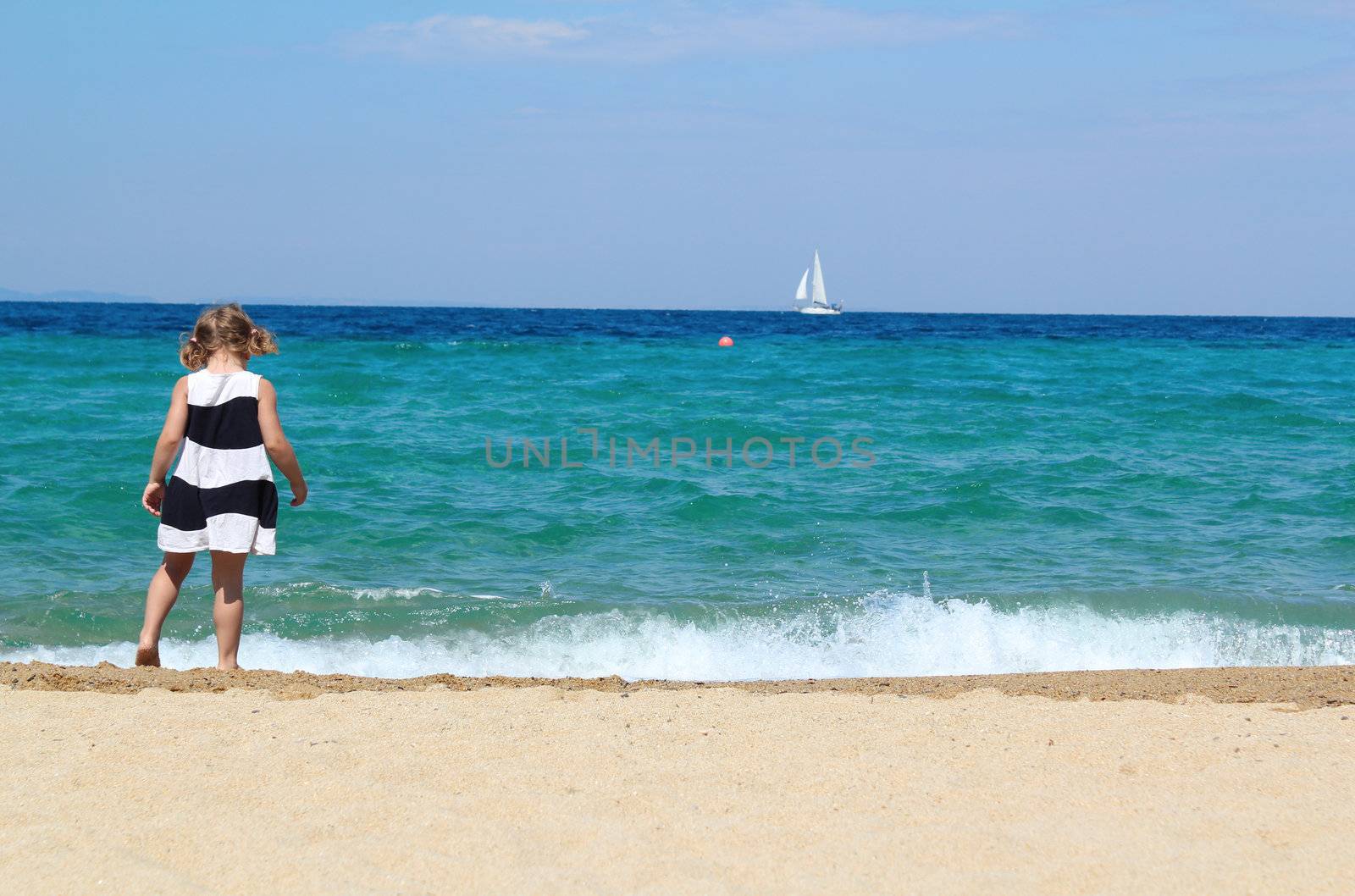 little girl walking on the beach by goce