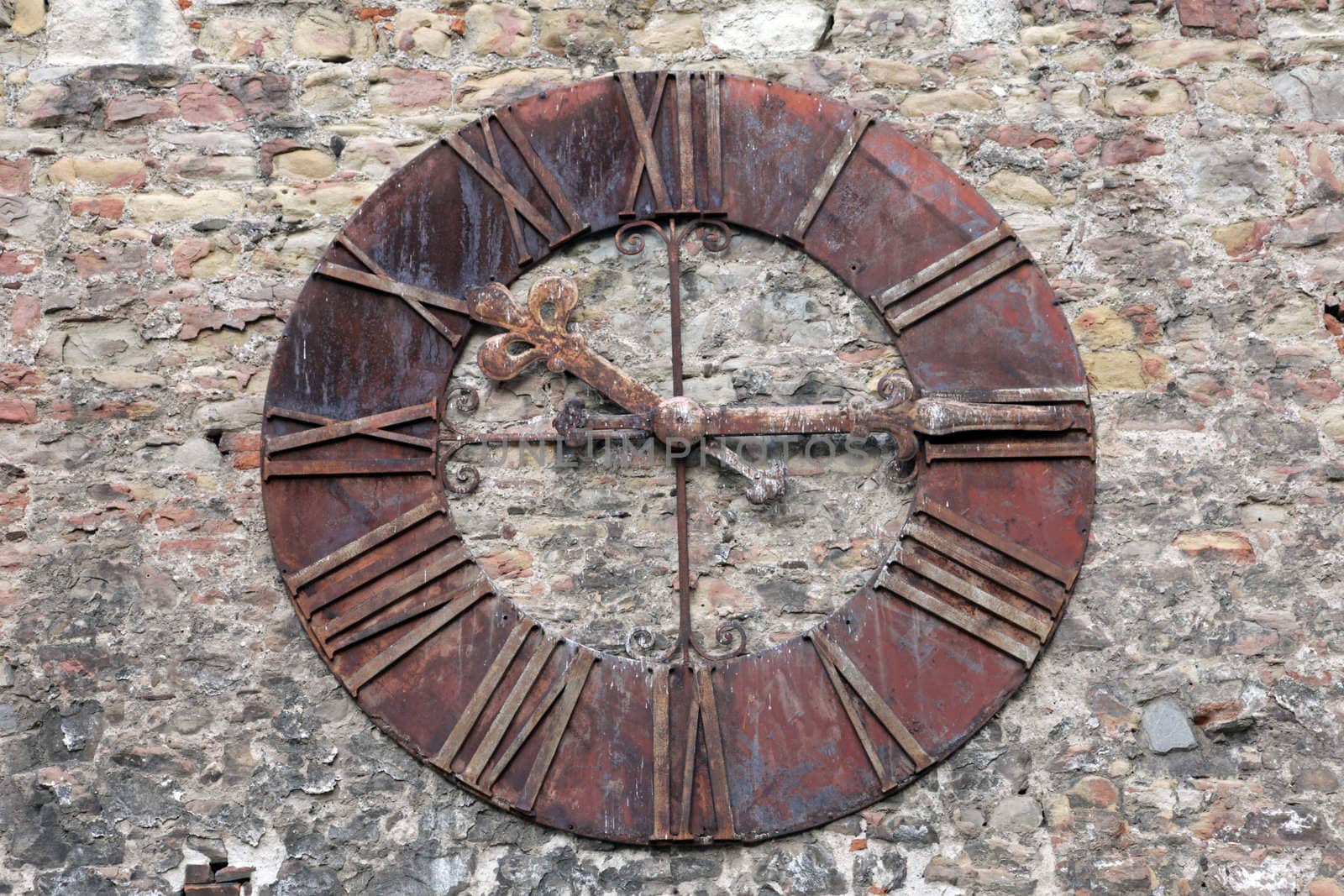 Rusty old clock on the wall by atlas