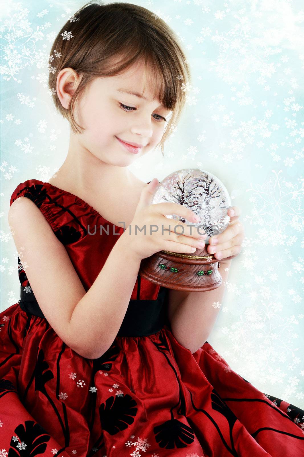 Happy little girl holding a snow globe.