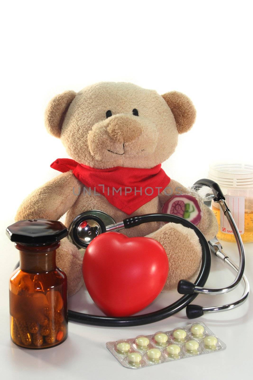 Teddy with a stethoscope and medication before a white background
