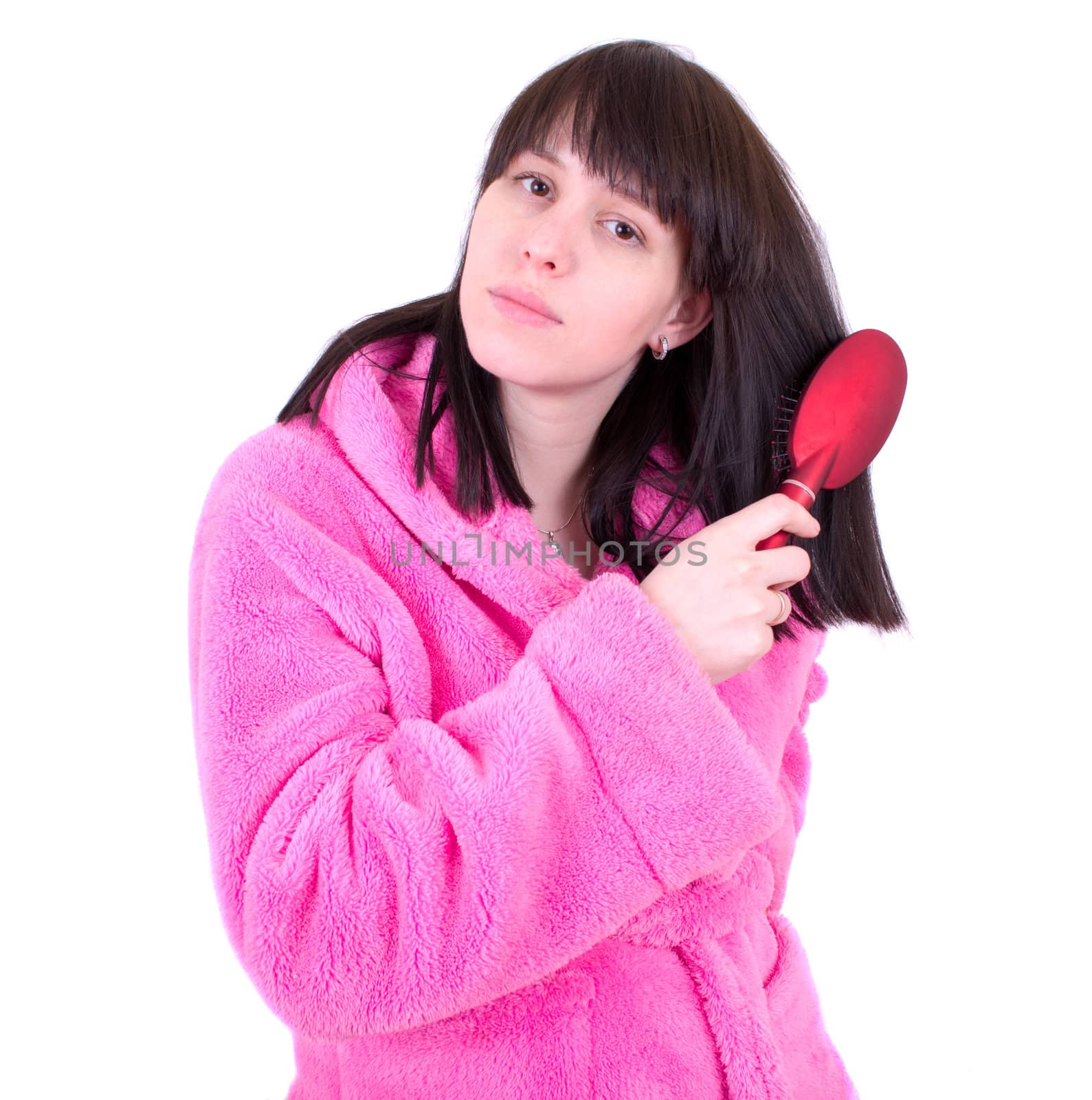 The young woman in a dressing gown combs hair a hairbrush