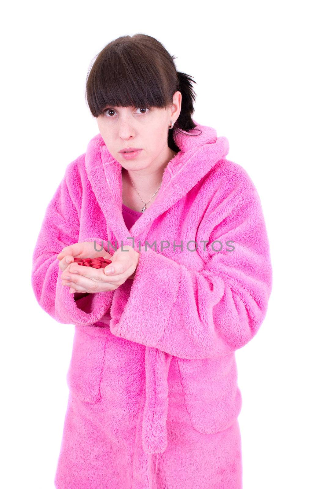 The young woman in a dressing gown holds a handful of tablets