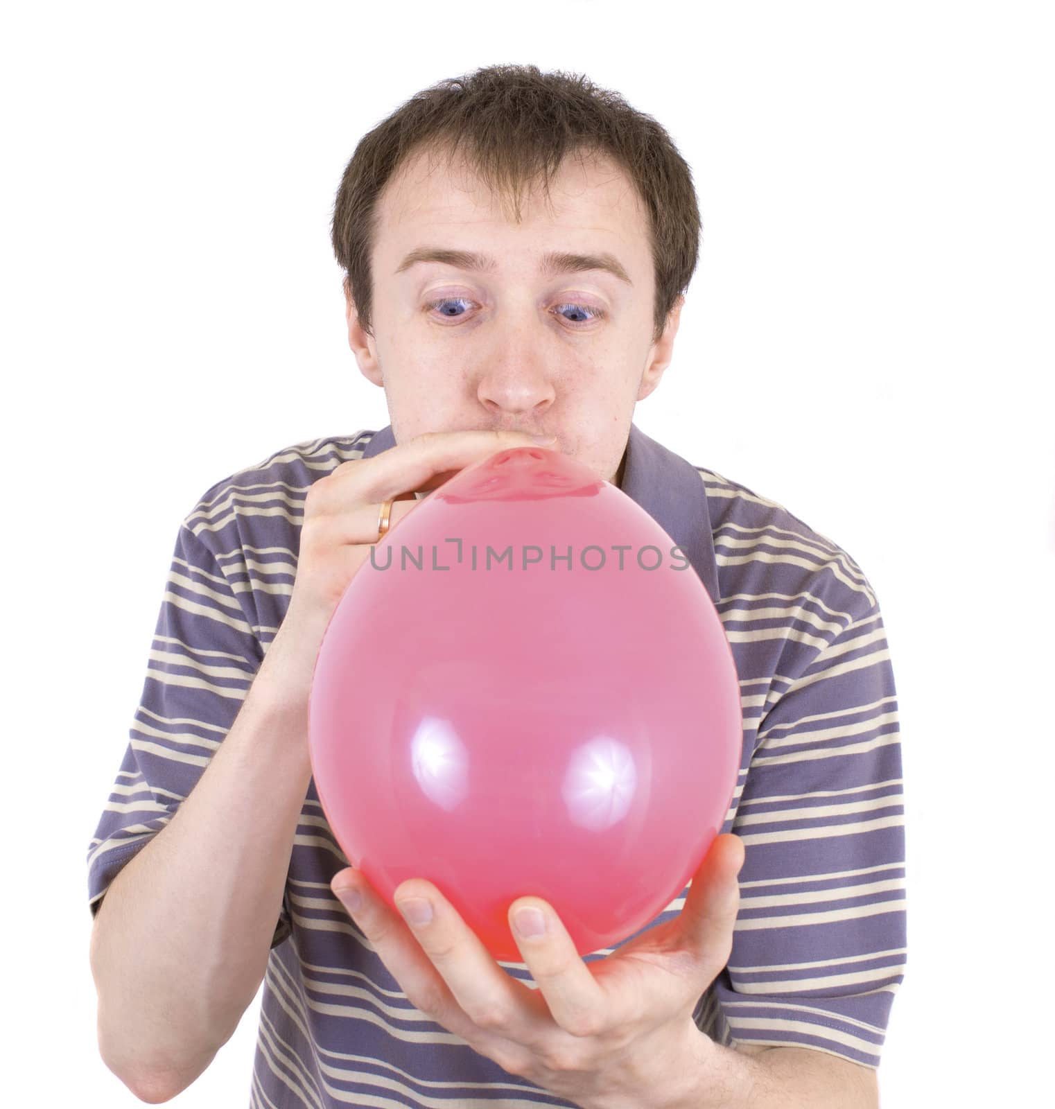 The young man inflates a red balloon