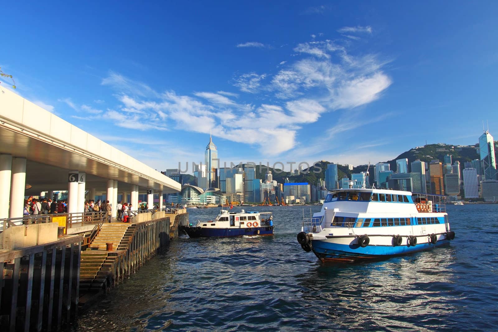 Hong Kong pier and skyline, there are many ships crossing Victoria Harbour per day.