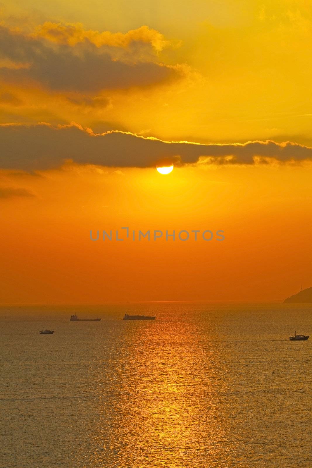 Sunset over the ocean with moving ships