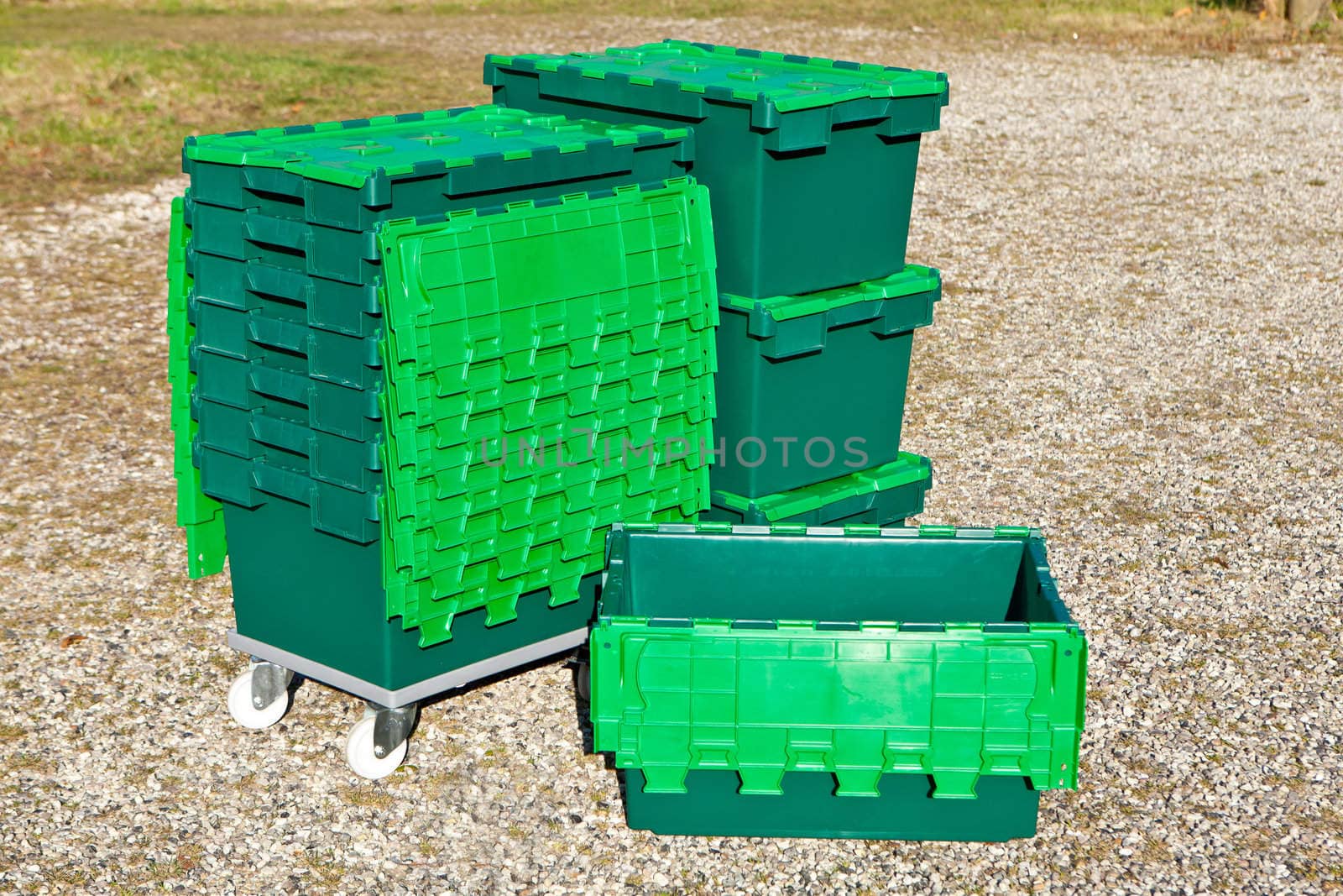 Stack of green plastic tote attached lid boxes