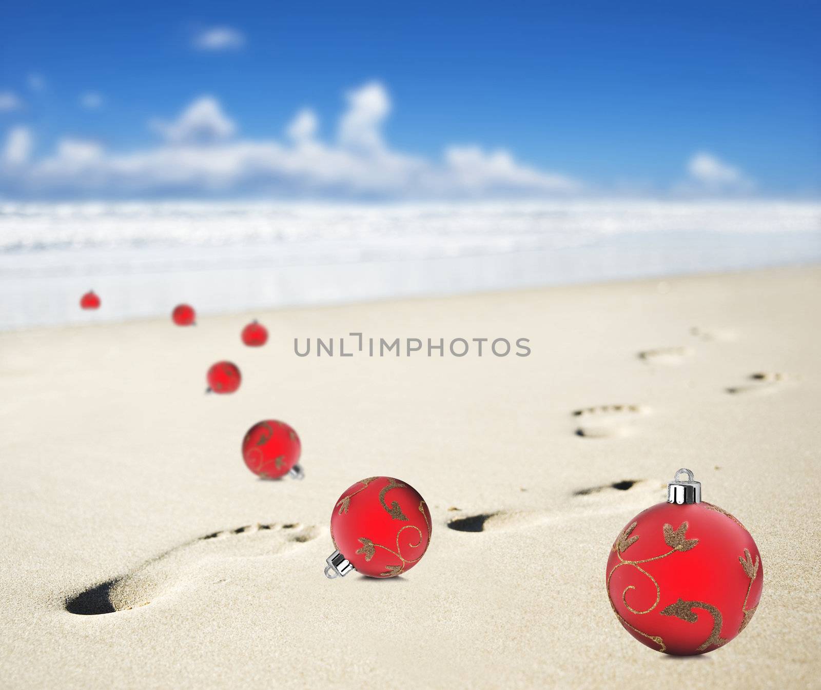 Christmas baubles on a beach with footprints by tish1