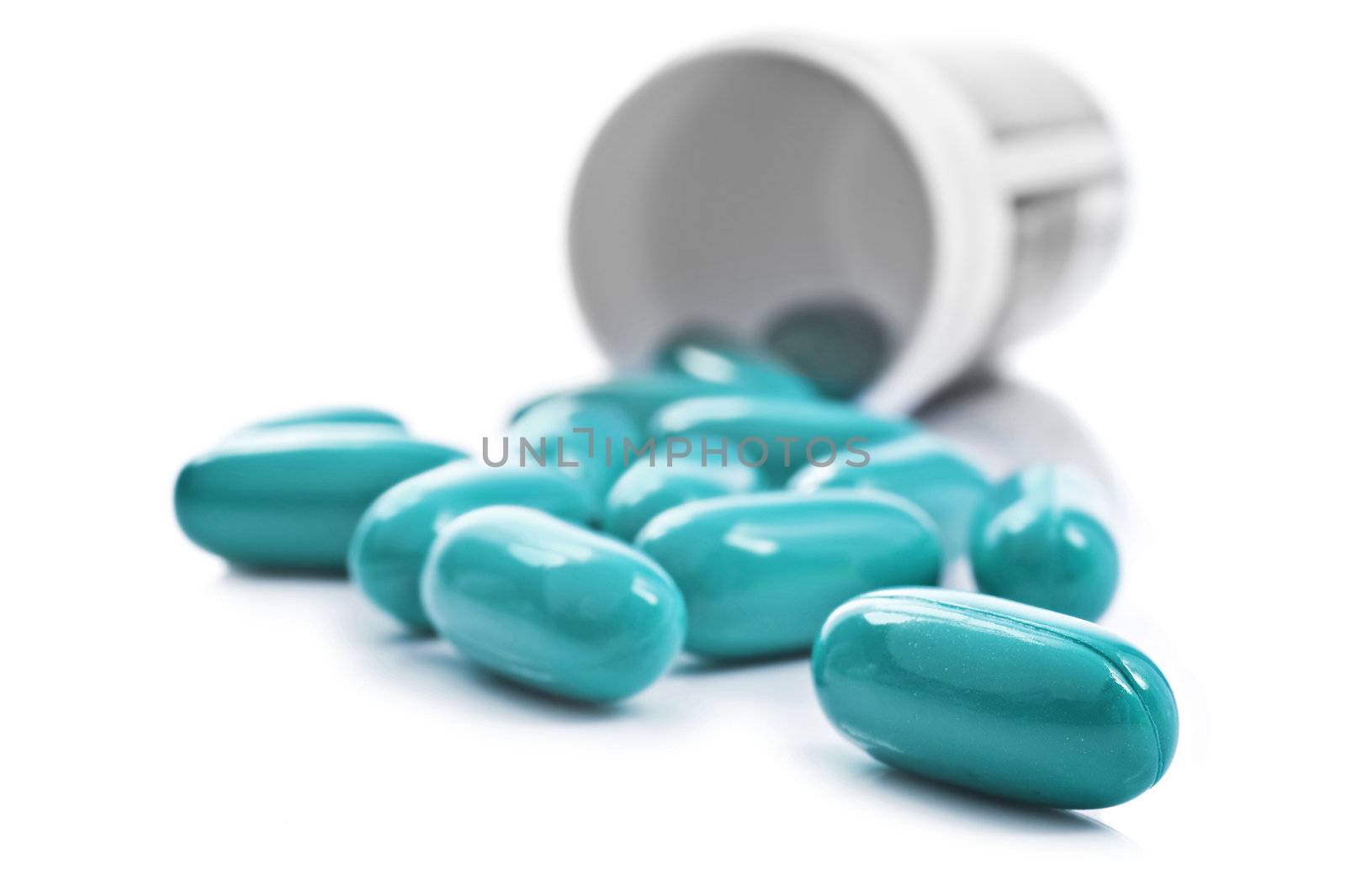 Blue pills an pill bottle on white background by tish1