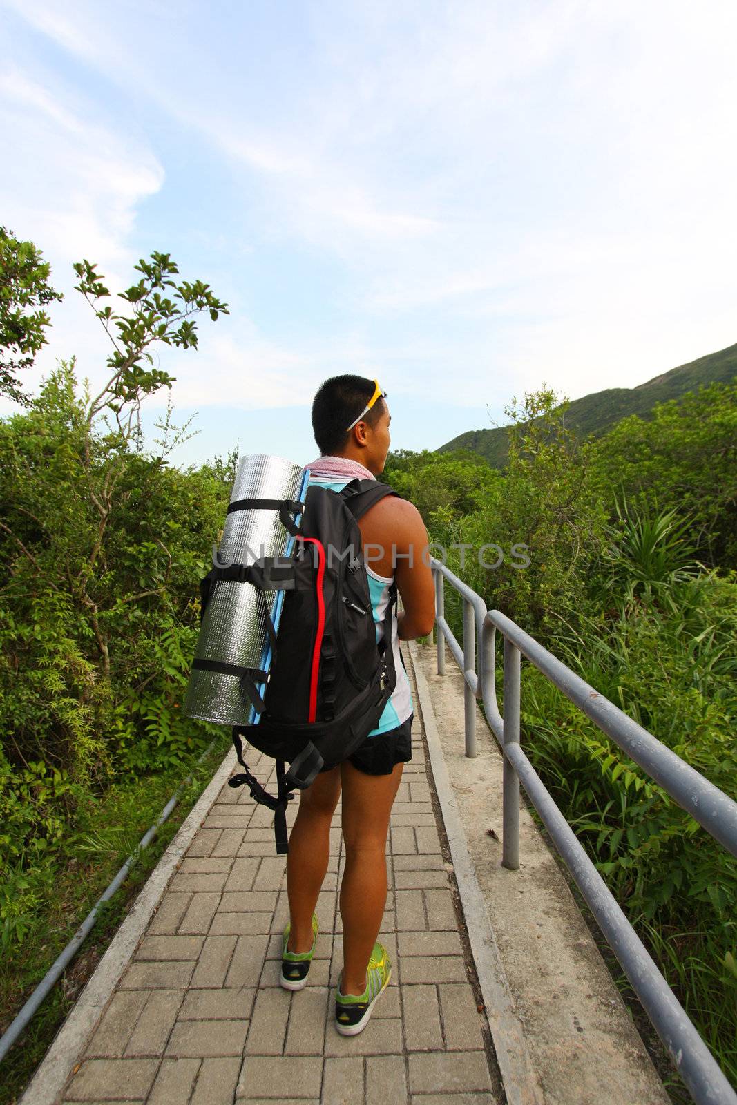 Asian man hiking on hiking trail 