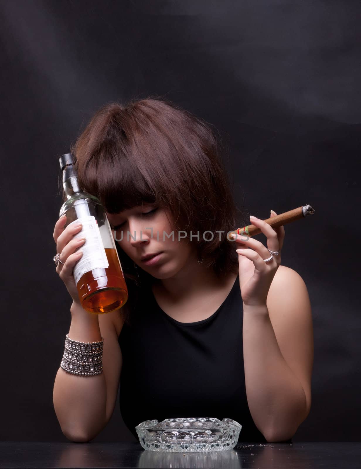 photo of woman drinks alcohol and smokes a cigar