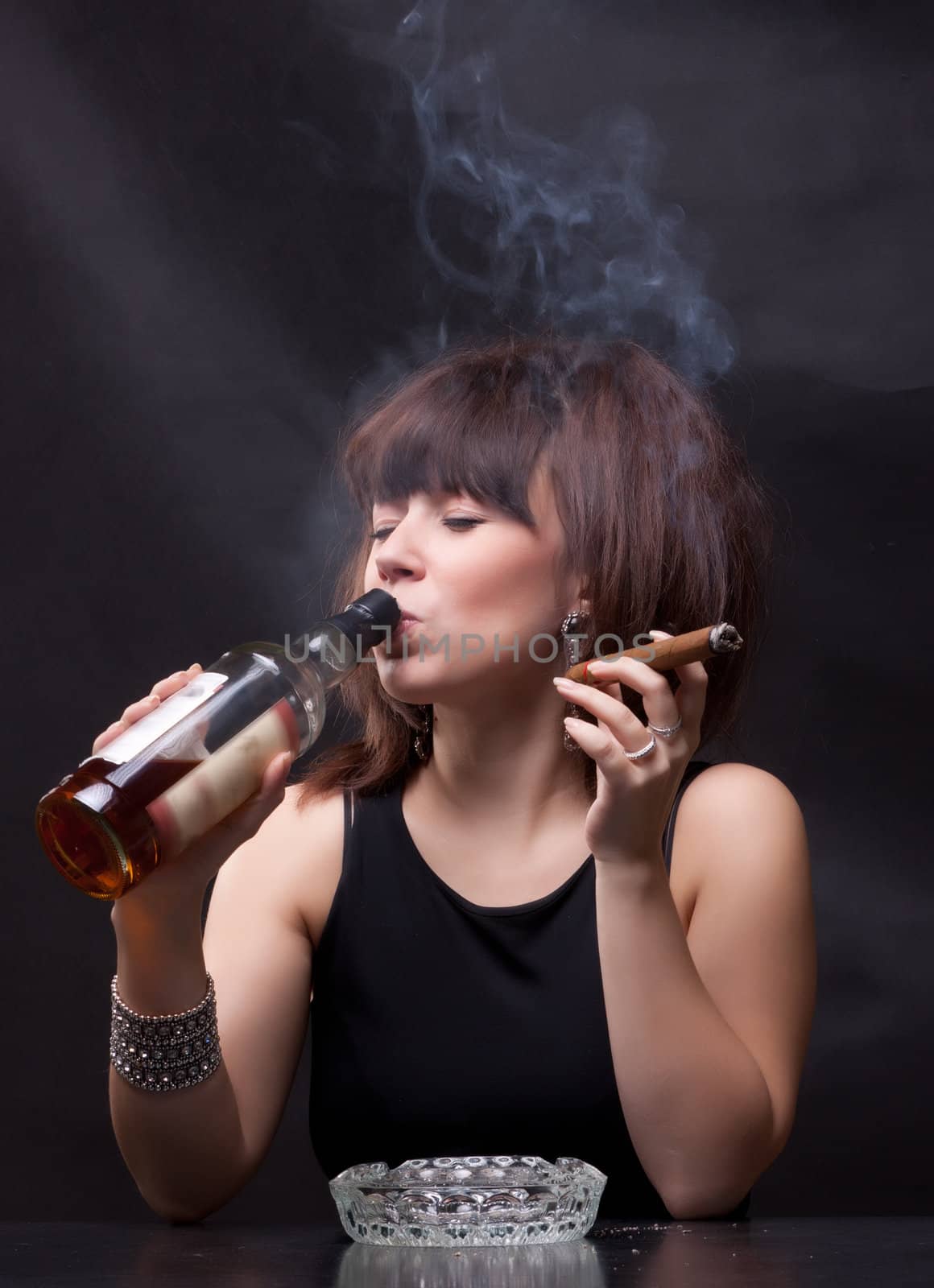 photo of woman drinks alcohol and smokes a cigar