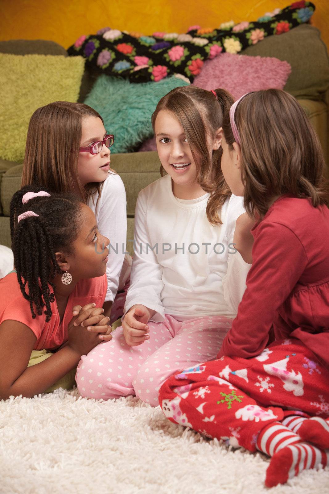 Four chatty little girls in pajamas at a sleepover