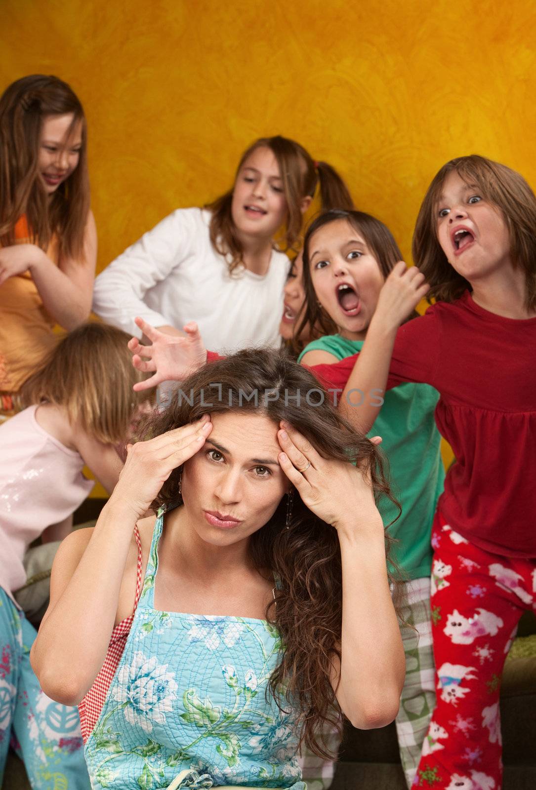 Babysitter holds head with wild little girls at a sleepover