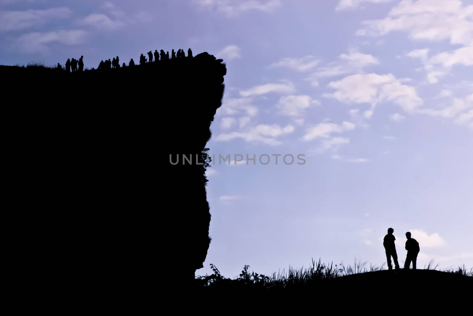 Man on peak of mountain.  by Suriyaphoto