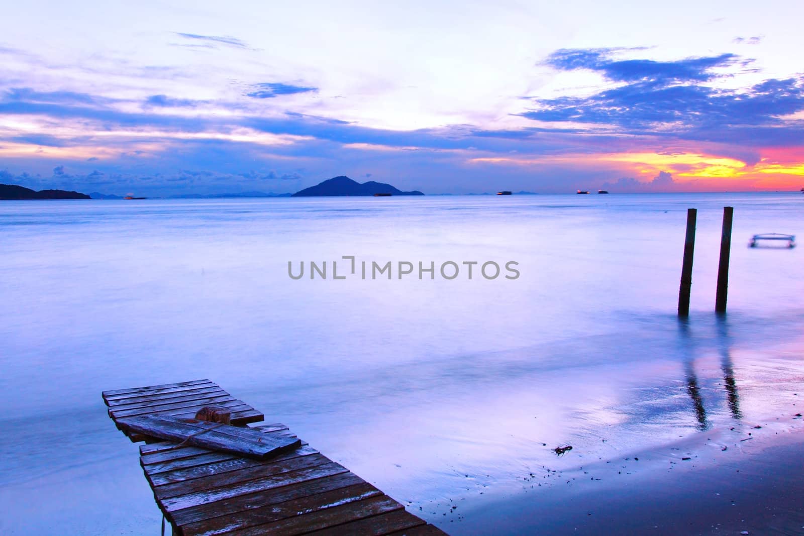 Sunset along a wooden pier by kawing921