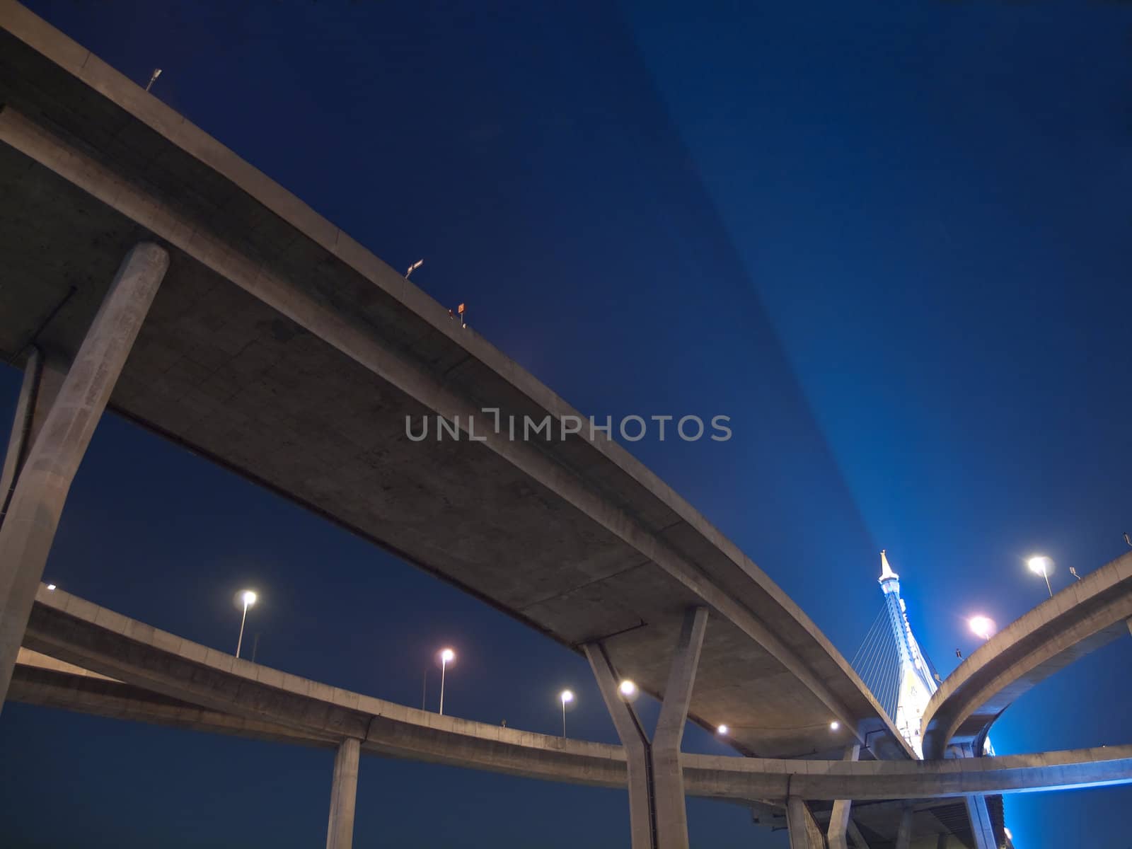 Intersection expressway with grade separation illuminate with spotlight on deep blue sky, Bhumibol Bridge, Samut Prakarn,Thailand